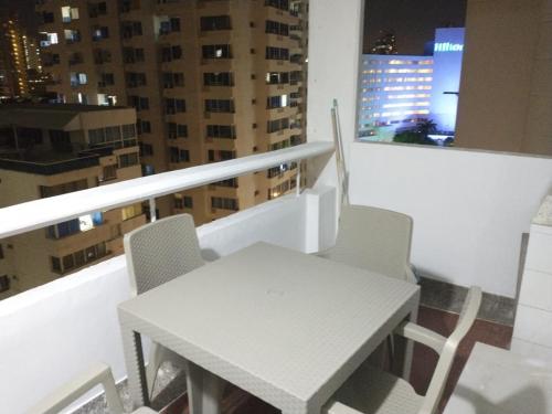 a white table and chairs on a balcony with buildings at Apartamento Playero in Cartagena de Indias