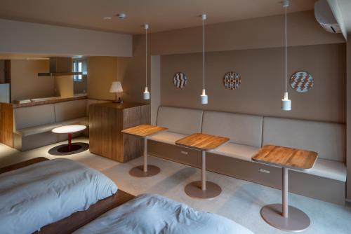 a room with two tables and a bed in it at Seven Stories in Nagoya