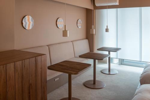 a living room with two tables and a couch at Seven Stories in Nagoya