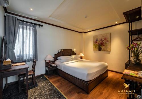 a bedroom with a large bed and a desk at Amanaki Saigon Boutique Hotel in Ho Chi Minh City