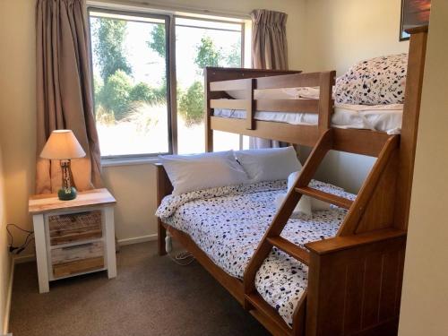 a bedroom with a bunk bed and a window at Stunning 360-degree views in Twizel