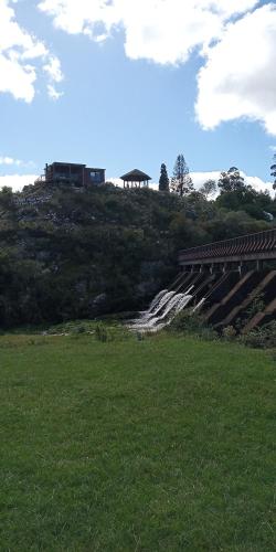 a grassy field with a bridge on top of a hill at Reconquista Villa Serrana in Villa Serrana