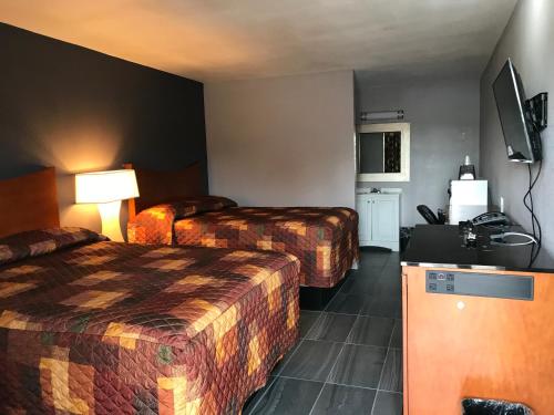 a hotel room with two beds and a television at Budget Inn & Suites in Amarillo