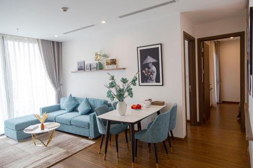 a living room with a blue couch and a table at Aspaces Serviced Apartments - Vinhomes West Point in Hanoi
