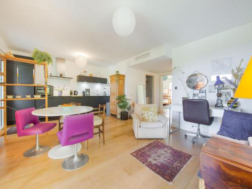 uma sala de estar com uma mesa e cadeiras roxas em Picturesque flat with swimming pool em Roquefort Les Pins