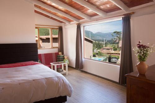 a bedroom with a bed and a large window at Sacred Valley View in Urubamba