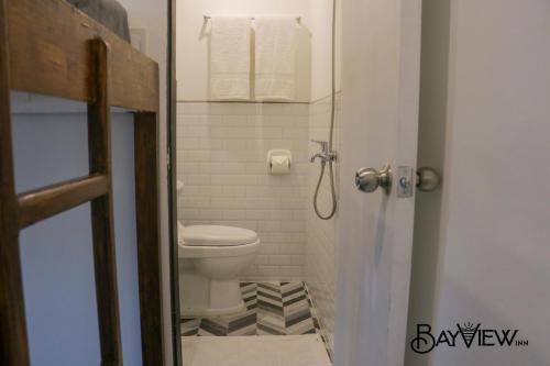 a small bathroom with a toilet and a shower at Bay View Inn in Surigao