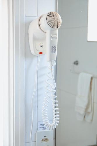a hair dryer is hanging on a wall at Hotel Arrastão in São Sebastião