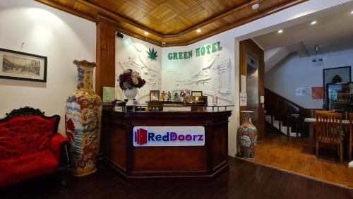 una librería roja con un sofá rojo en una habitación en Green Hotel near Lotte Center, en Hanói