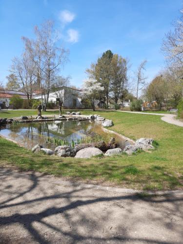 a pond in a park with rocks in the grass at Moderne 3Zimmer Wohnung, in Königsbrunn bei Augsburg in Königsbrunn