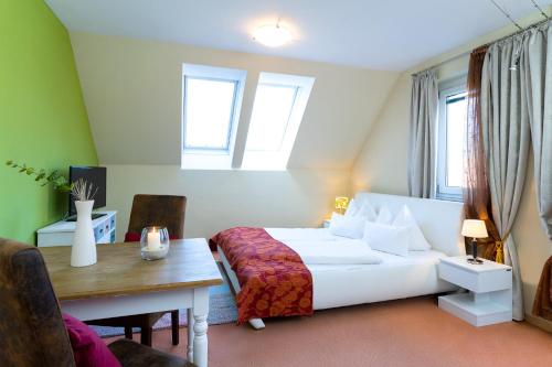 a bedroom with a bed and a table and a desk at Hotel Garni Pölzl in Deutschlandsberg