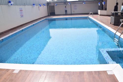 a large swimming pool with blue water in a building at Hotel JMD International Purnea in Pūrnia
