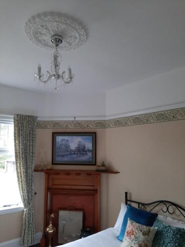 a bedroom with a bed and a chandelier at Wainono Homestead in Waimate