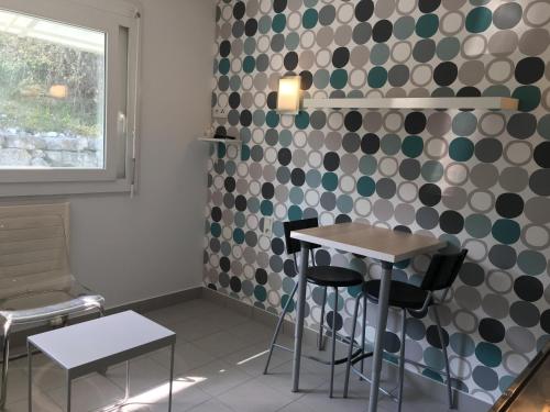 Cette chambre dispose d'une table, de chaises et d'un mur avec des points de polka. dans l'établissement STUDIO SUR LE PORT, au Bourget-du-Lac