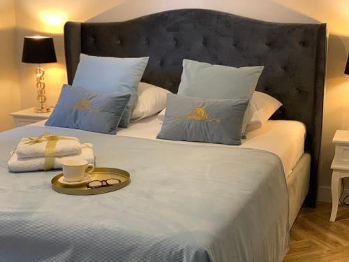 łóżko z biało-niebieskimi poduszkami i tacą w obiekcie Apartamenty Kamienica Arte 3 w Ustce