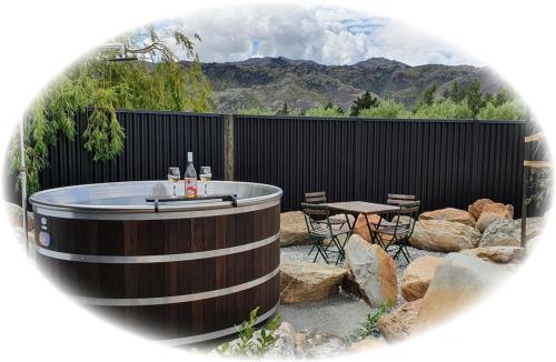 a hot tub in a backyard with a table and chairs at River Rock Estate in Cromwell