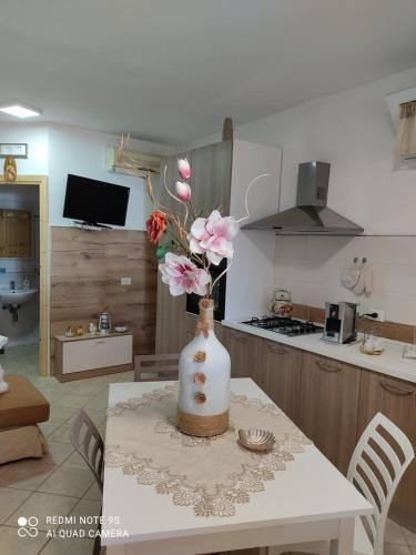 un vaso con fiori su un tavolo in una cucina di Baglio Cracchiolo da Tuzzo - Casa Il Limone a San Vito lo Capo