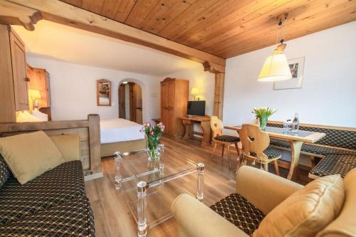 a living room with a bed and a dining room at Hotel Steinbock in Klosters