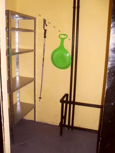 un vase vert sur le mur à côté d'une étagère dans l'établissement Studio sur les pistes, à Bagnères-de-Bigorre