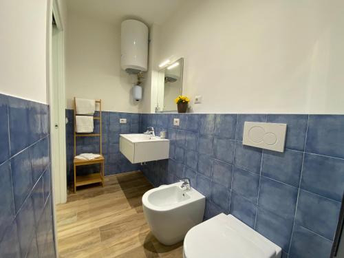 a blue tiled bathroom with a toilet and a sink at Sogni di Sabbia in Porto Potenza Picena