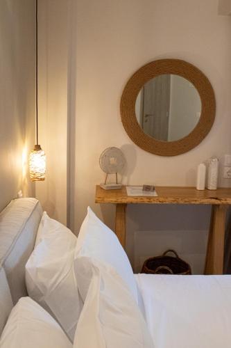 a bedroom with a white bed and a mirror at Langhi Apartments 2 in Mesolongion