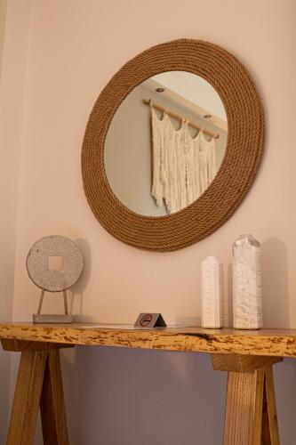 a mirror on a wall above a wooden table at Langhi Apartments 2 in Mesolongion