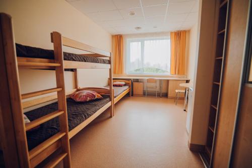 um dormitório com 2 beliches e uma janela em Valmieras tehnikuma dienesta viesnīca em Valmiera