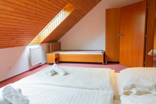een slaapkamer met een bed en een bank op zolder bij Apartmány Snežienka in Stary Smokovec