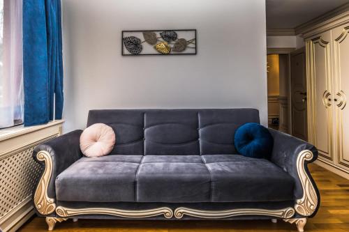un sofá sentado en una sala de estar junto a una ventana en Sky Park Home, en Iaşi