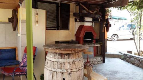 une cuisine extérieure avec une table et un four à pizza dans l'établissement Apartments Peter, à Dobrinj