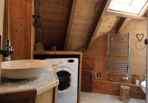 une cuisine avec un évier et une machine à laver dans l'établissement VAUJANYLOCATIONS - Le Grenier de Germaine, à Vaujany