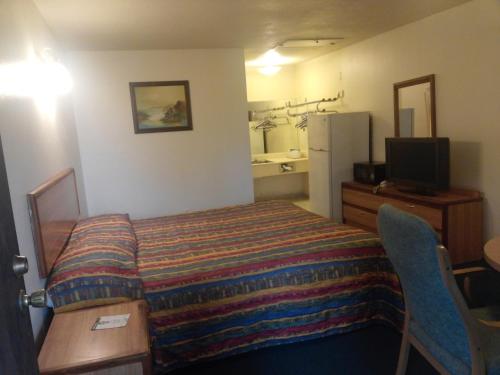 una camera d'albergo con letto e frigorifero di Evergreen Inn a Covina
