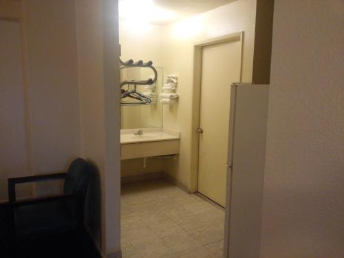 un piccolo bagno con lavandino e specchio di Evergreen Inn a Covina