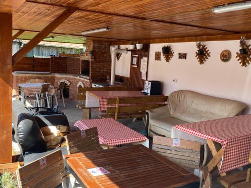 a patio with tables and couches and a couch at Rajni Panzió in Praid