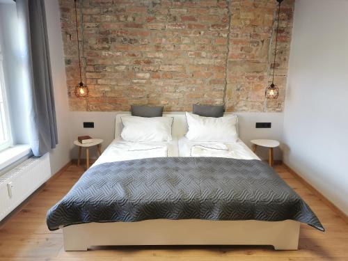 a bedroom with a bed and a brick wall at Gästehaus Vergissmeinnicht in Guteborn