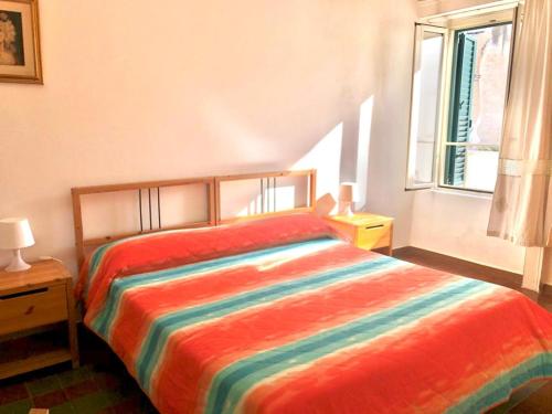 een slaapkamer met een kleurrijk bed en een raam bij Rocca Sul Mare Hotel in Vieste