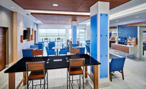 a dining room with blue chairs and a table at Holiday Inn Express & Suites Windsor East - Lakeshore by IHG in Lakeshore