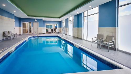 a pool with blue water in a hotel room at Holiday Inn Express & Suites Windsor East - Lakeshore by IHG in Lakeshore