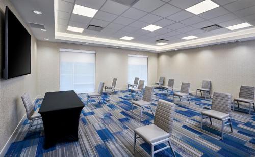 a conference room with chairs and a table and a screen at Holiday Inn Express & Suites Windsor East - Lakeshore by IHG in Lakeshore