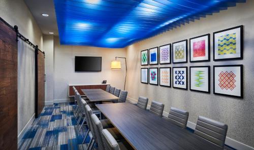 a conference room with tables and chairs and a tv at Holiday Inn Express & Suites Windsor East - Lakeshore by IHG in Lakeshore