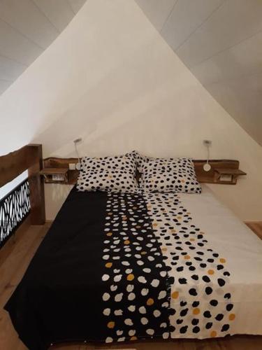 Cette chambre dispose d'un grand lit avec des oreillers en peluche à la polka. dans l'établissement Entre Terre et Mer, à La Méaugon