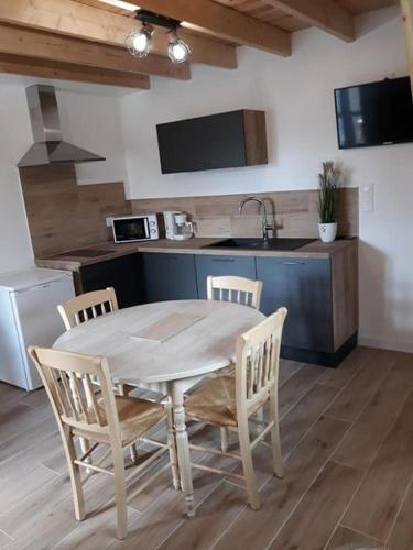 une cuisine avec une table et des chaises dans une pièce dans l'établissement Entre Terre et Mer, à La Méaugon