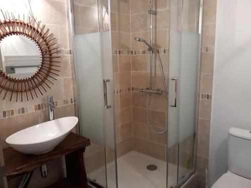 La salle de bains est pourvue d'une douche, d'un lavabo et d'un miroir. dans l'établissement Entre Terre et Mer, à La Méaugon