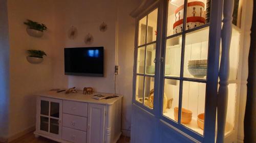 a room with a cabinet and a tv on a wall at Alter Priesterhof - Idyllische Ferienhausvermietung in Nykøbing Falster
