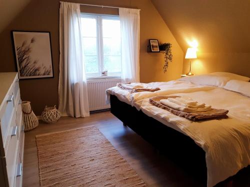 a bedroom with a large bed and a window at Alter Priesterhof - Idyllische Ferienhausvermietung in Nykøbing Falster