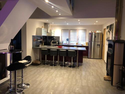 La cuisine est équipée d'un bar avec tabourets et d'un réfrigérateur. dans l'établissement Chambon-sur-Lac, à Chambon-sur-Lac