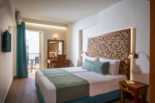 um quarto de hotel com uma cama grande e uma varanda em Anesis Blue Boutique Hotel em Hersonissos