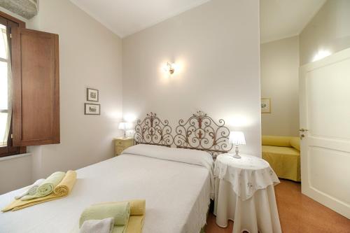 a white bedroom with a bed and a table at B&B A casa di Teresa in Olbia