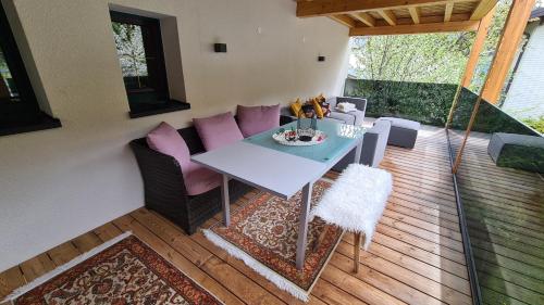 un patio con mesa y sillas en una terraza en Jagd trifft Moderne & Boutique Jardin Ferienhaus, en Annaberg im Lammertal