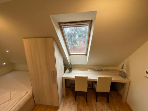 a room with a desk with two chairs and a window at Royal Mediterran in Siófok